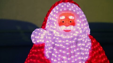Snowman Santa Claus with many lamps, closeup view in motion