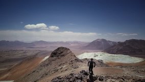 Male trail-runner on summit of the volcano Toco on Atacama desert, 4k. Aerial view of a man running down of a volcano peak.
