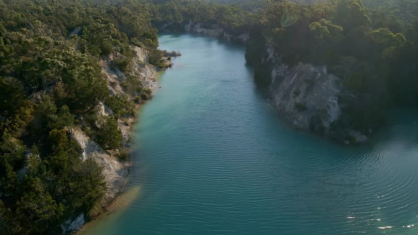 Profile view of a little blue lake in Tasmania with turquoise water in Australia. Aerial shot.
