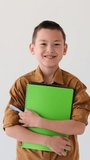 Happy Schoolboy Holding Notebook Portrait On White Background