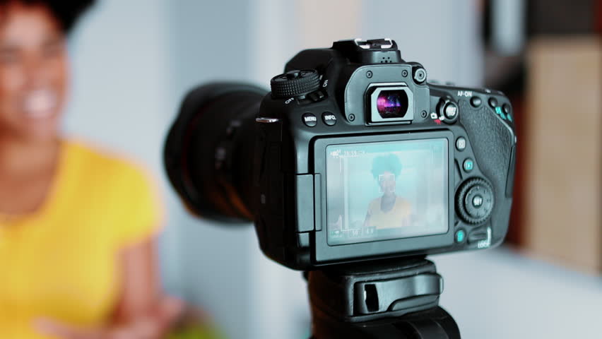 Close-up camera filming video vlogger, gesturing in blurred background. Person creating a video to post in online channel. woman engaged with new media communication, posting testimonial