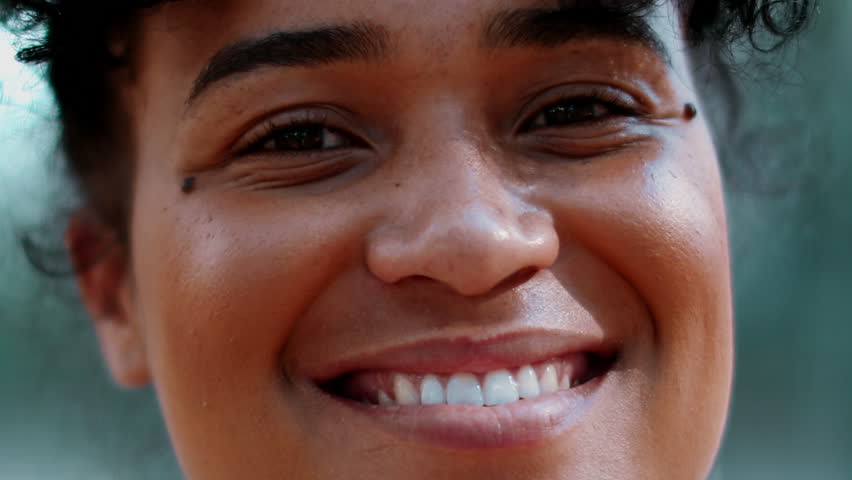 Joyful Young Black Brazilian Woman Smiling at Camera, Tracking Close-Up Shot of 20s South American Female with Curly Hair, African Descent with Friendly Expression