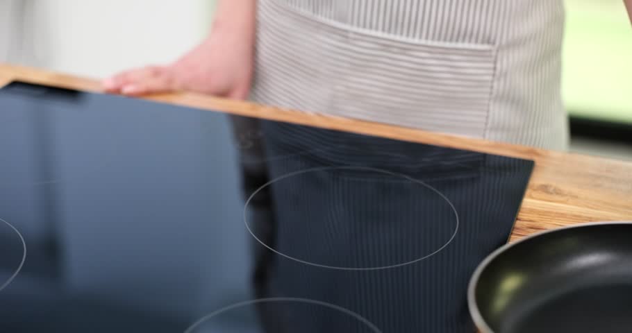 Cook putting frying pan and turning on stove closeup 4k movie slow motion. Cooking at home concept