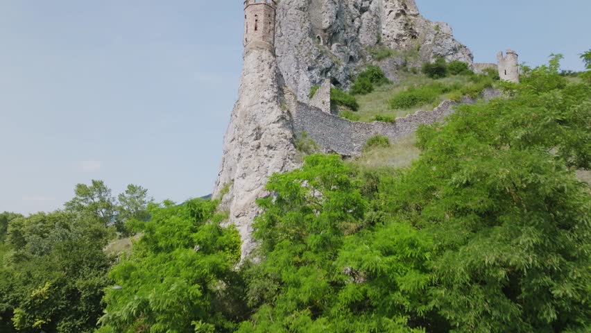 Drone aerial view of historical Maiden Tower of Devin castle (Hrad Devin) near Dabube and Morava rivers in Bratislava, Slovakia on sunny day. (4K)