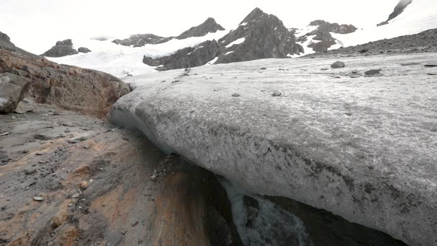 Alpine landscape. Glacial meltdown. View of the rock, ice field and cave in Glacier Vinciguerra in Ushuaia, Tierra del Fuego, Patagonia Argentina. The fresh water subterranean river flowing downhill. Royalty-Free Stock Footage #3477334077