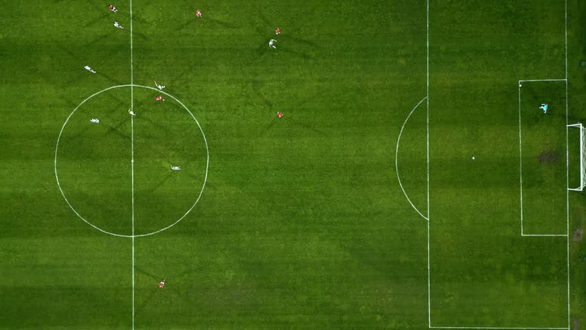 Aerial view of a soccer field in action, with players running, passing, and scoring goals.