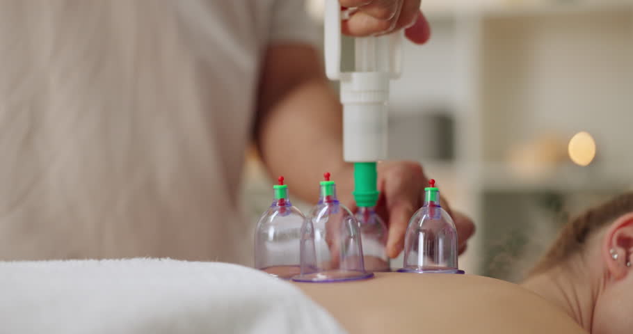 Masseur, cupping therapy and back of person in spa for treatment, body or muscle pain with vacuum cups. Massage or therapist, client and skincare with jar for health, wellness and relax or rest