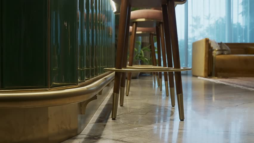 Modern Minimalist Bar Stools With Upholstered Round Shape, Tapered Lacquered Legs, and Brass Details. ascending shot, side view Royalty-Free Stock Footage #3477374815
