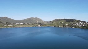 Discover the tranquil beauty of a Southern Italian Lake d'Averno captured from above by a drone: serene waters, lush greenery, and quaint lakeside villages create a mesmerizing view