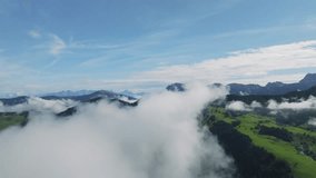 Drone flies amidst clouds revealing Dolomite peaks in the background. Aerial footage over La Val village in the valley. Summer morning's breathtaking aerial video. LuPa Creative