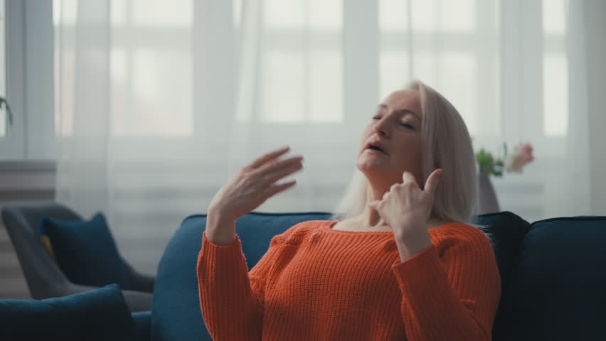 Middle-aged woman suffering from a hot flash, heavy sweating, menopause symptom