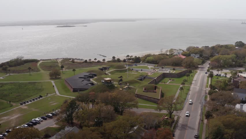 Descending and panning aerial shot of historic Fort Moultrie along the Atlantic Coast during a day with low visibility on Sullivan