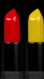 Close-up footage of bright coloured lipstick turning against a plain white background in vertical format