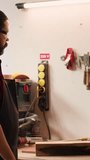 Vertical video Woodworker using bench vise to hold lumber block, starting furniture assembling in workshop. Craftsperson in joinery using vice tool to clamp piece of wood before carving it, camera A