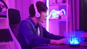 Asian attractive Esport male gamer play online video game on computer. Handsome upset man gaming loser player feel frustrated and angry while broadcast live streaming playing cyber tournament at home.