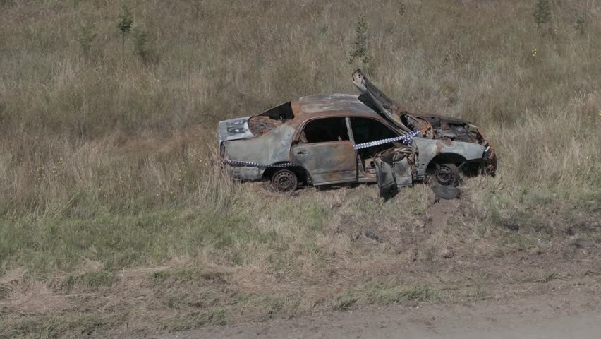 Burnt out car with police tape