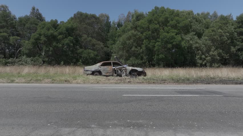 Burnt out car with police tape