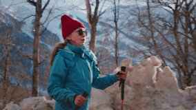 Old gray-haired woman hiking in the winter mountains. The senior female uses sticks for Nordic walking. Hiking to the Snowy peaks in the national Park. Elderly Granny's Face, hiking.  - Powered by Shutterstock - Get 15% off with code: PIKWIZARD15