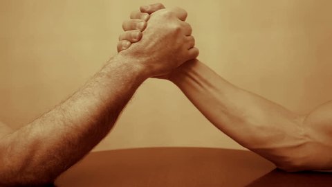 Two men arm wrestling.