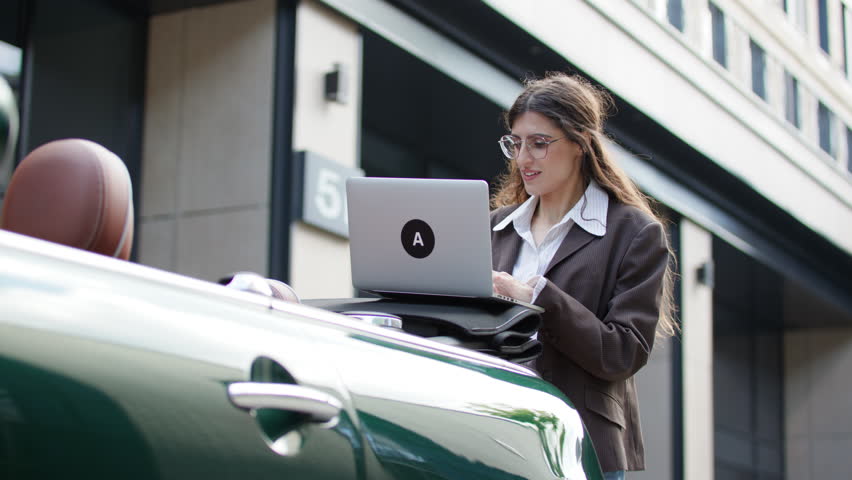Businesswoman Working on Laptop by Convertible Car