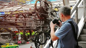 Video 1920X1080 - Photographer shooting messy. spaghetti-like telecommunications transmission wires over a busy urban street in Bangkok. Thailand. with sound.