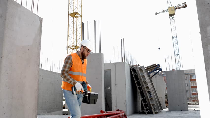 Funny construction worker dancing. Positive dance of builders in helmet. Construction engineer in builder uniform dancing on his work place