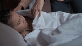 Mother's hands carefully cover her sleeping 8-year-old daughter in bed with a white blanket. Woman cover a child sleeping in bed and enjoy dreams. Comfortable sleep on a comfortable mattress. - Powered by Shutterstock - Get 15% off with code: PIKWIZARD15