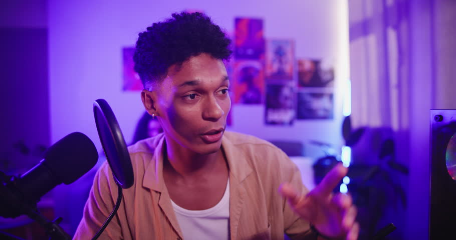 Man, gamer streaming online and microphone with face, esports competition or tournament with chat at home. Neon light, content creation and pro gaming for social media with internet for followers