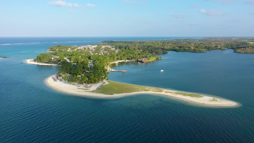 Drone overhead view of the beach of Constance Belle Mare Plage in Mauritius, with palm trees, umbrellas and a beautiful turquoise sea with transparent water. Luxury 5 star hotel in Mauritius.