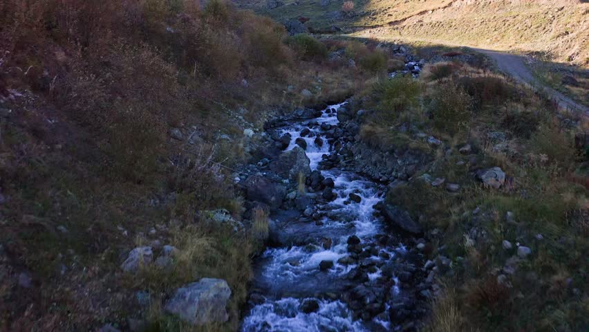 Mountain creek among autumn color meadows in highland area of Georgia