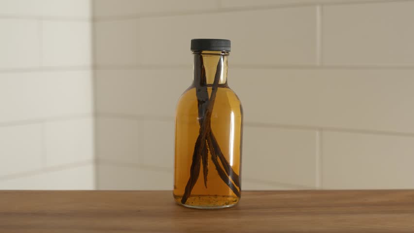 Hand setting down bottle of homemade vanilla extract.