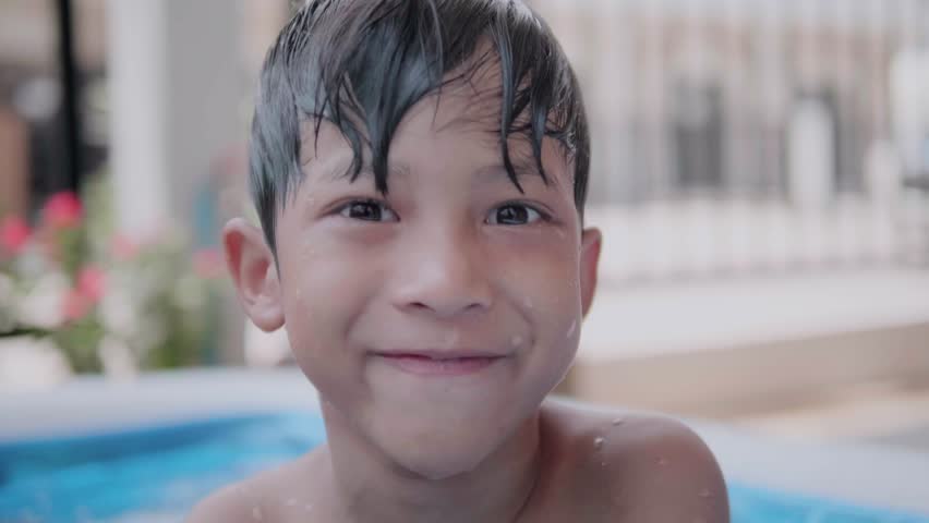 Two cute Asian children happily playing in an inflatable pool in summer. including jumping into the water, diving in the inflatable pond