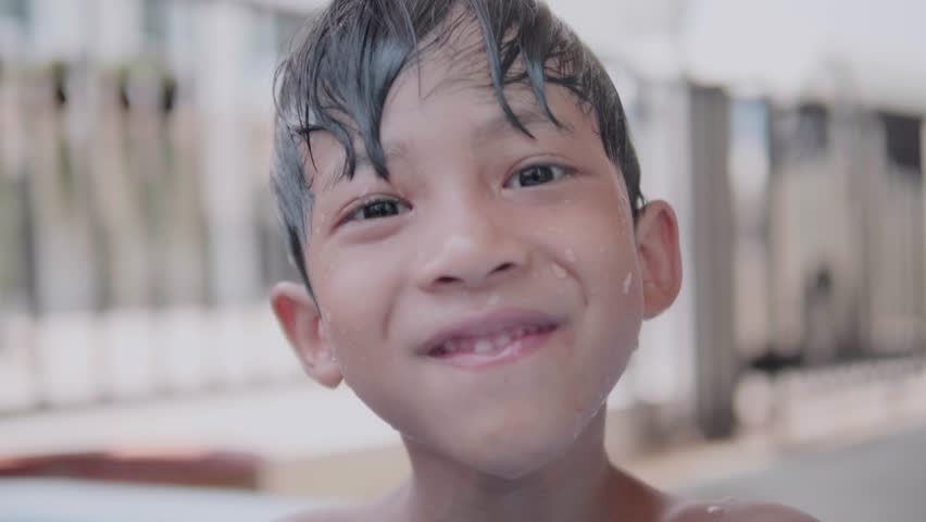 Two cute Asian children happily playing in an inflatable pool in summer. including jumping into the water, diving in the inflatable pond