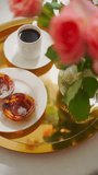 Traditional Portuguese pastry pastel de nata, coffee and roses on a golden tray top view vertical video. 4K 