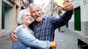 Happy senior couple taking selfie with mobile phone in the city. Elderly tourist and travel vacations - Powered by Shutterstock - Get 15% off with code: PIKWIZARD15