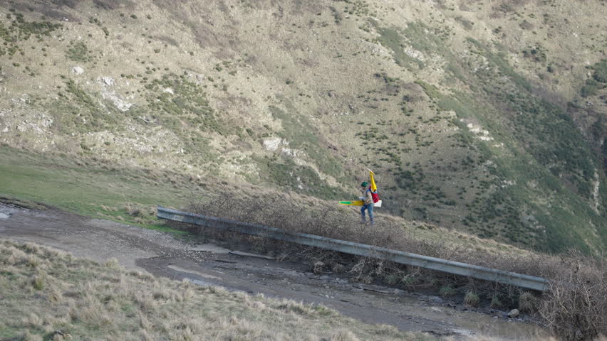 An unrecognizable man carries something while walking