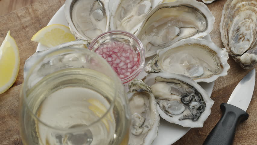 Fresh raw edible oysters, popular shellfish seafood close-up. Mollusk marine oysters. Man's hand squeezes a lemon Royalty-Free Stock Footage #3478133065
