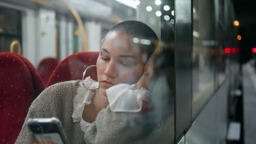 Portrait voyager sitting train looking mobile phone screen. Sad short hair woman leaning window railway wagon waiting departure close up. Boring railroad passenger watching social media by cellphone.