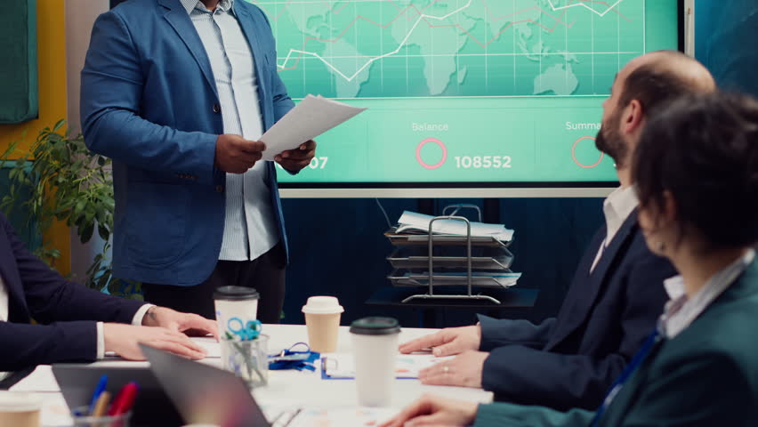 Project manager meeting with his executive team in a boardroom office, looking into updates on regulatory changes that can affect their tasks. Leader sharing gathered analysis on papers. Camera A. - Powered by Shutterstock - Get 15% off with code: PIKWIZARD15