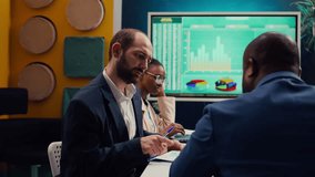 Accounting experts studying sales trends and market demands to ensure project success, looking into data infographics in executive meeting. Financial department team reviews revenue funds. Camera B - Powered by Shutterstock - Get 15% off with code: PIKWIZARD15