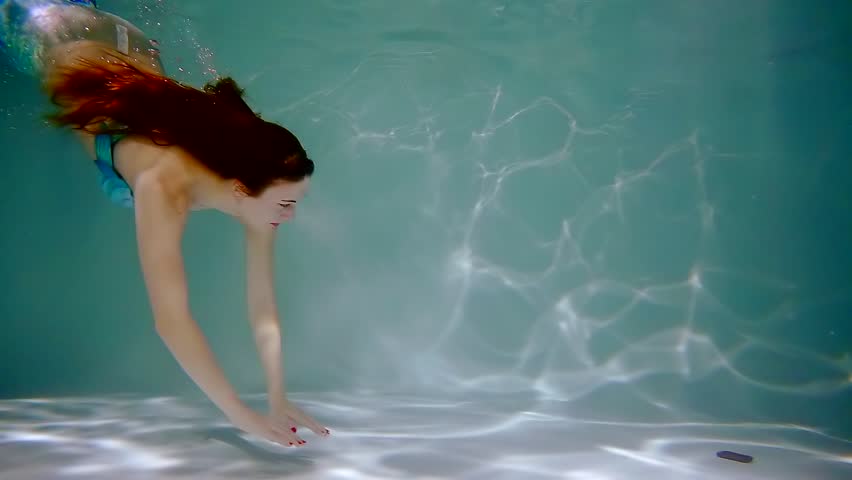 mermaid girl with long red hair swimming underwater
