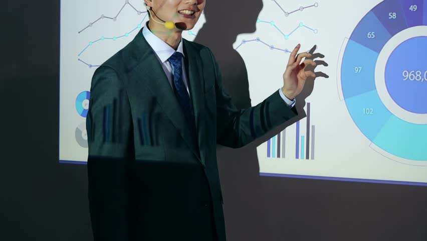 Asian man giving a presentation using a projector Royalty-Free Stock Footage #3478233819