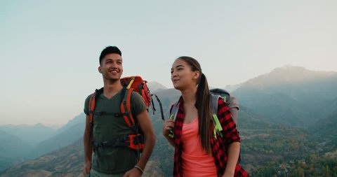 young asian couple of tourists doing selfie reaching the top of the mountain