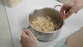 The video shows oatmeal cooking in a saucepan, demonstrating the process of preparing a healthy breakfast. Suitable for culinary clips and promoting a healthy lifestyle