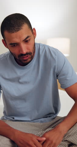 Stress, upset and man on bed at a home with regret, fail or mistake for insomnia or sleeping problem. Worried, burnout and tired male person with unhappy face for exhaustion in bedroom of house. Royalty-Free Stock Footage #3478345279