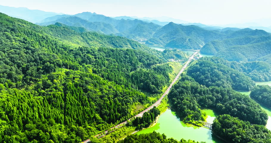 Aerial view of road highway in the middle of mountains. Beautiful natural landscape in summer. Drone descent shot.