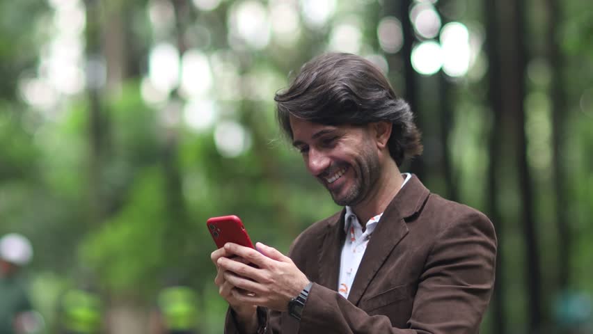 View of one young man with smartphone at daytime in a green park in the city.  Royalty-Free Stock Footage #3478371767