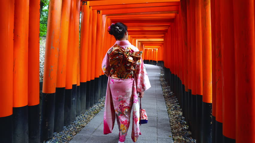 Asian women in traditional japanese kimonos visiting at Fushimi Inari Shrine in Kyoto, Japan.