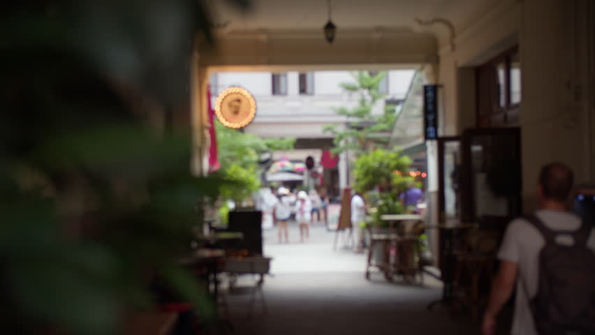 Soft focus view from a cafe on Kiraly Street in Budapest, Hungary, capturing the lively ambiance with blurred figures and shops in the urban passage