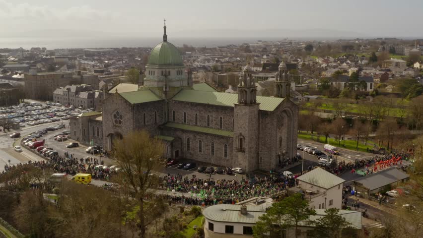 Aerial parallax of Galway Cathedral as families join together to watch parade in Ireland